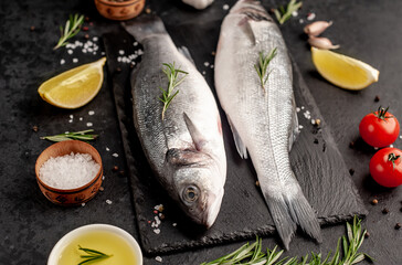 Sea bass fish with spices on a stone background