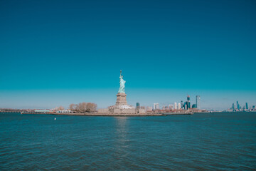 Naklejka premium Foto de la Estatua de la Libertad con los rascacielos de fondo, Nueva York