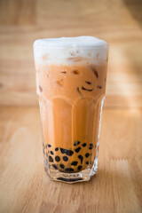 Asian style orange bubble tea with milk froth on top