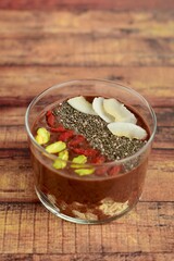 Healthy banana chocolate avocado smoothie drink top with pistachio, goji berry, coconut chip and chia seeds