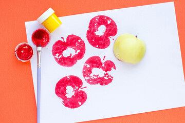 Children's crafts. Print of apples on colored paper.