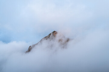 Mountain peak in the clouds. Mount Black Pyramid in Krasnaya Polyana. Fog in the mountains.