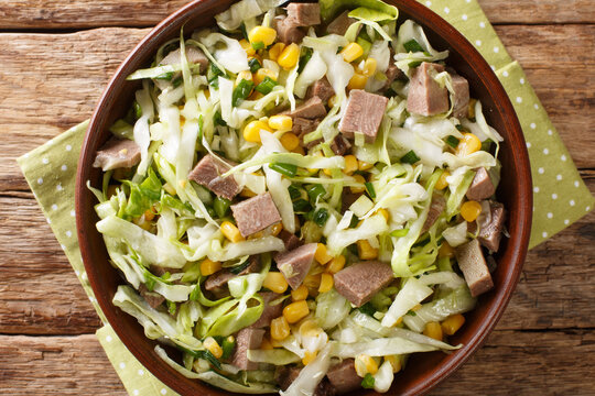 Fresh Salad With Beef Tongue, Cabbage And Corn Close-up In A Bowl On The Table. Horizontal Top View From Above