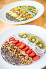 Two different Smoothie bowl with a selection of fruit granola, chia seed and coconut yogurt