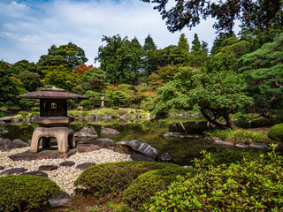 池のある、秋の日本の伝統的な庭園の風景