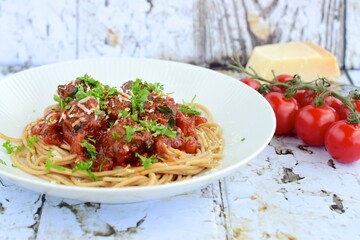 spaghetti with meatballs in tomato sauce garnish with parmesan cheese and parsley