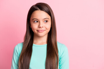 Fototapeta premium Photo of funny interested lovely cute small latin lady long hairdo look side empty space smile wear casual stylish trendy turquoise teal sweatshirt isolated pink color background