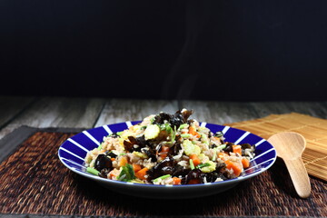Fried and stirred cooked rice with fresh cutting carrot, sliced baby corn, black jelly fungus and Chinese celery on the plate. Famous traditional vegetarian menu in Asia restaurant. High fiber.