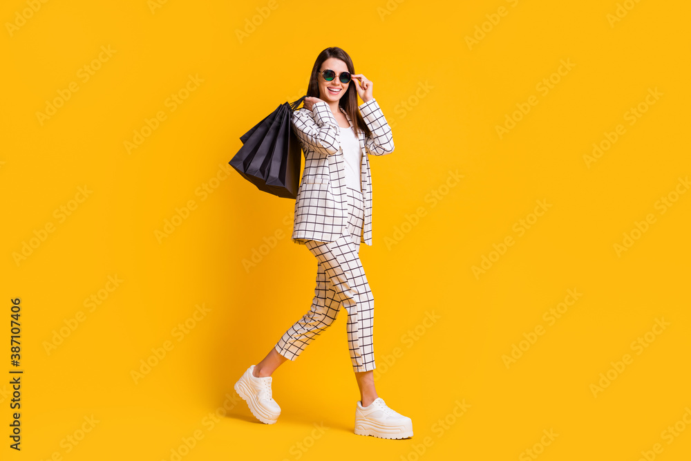 Poster full length body size photo of happy girl keeping black friday shopping bags touching sunglass isola