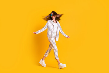 Full length body size side profile photo of girl wearing checkered suit round sunglass going fast isolated on vibrant color background