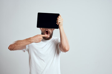 emotional man with a tablet in front of his eyes gesturing with his hands cropped view Copy Space Model light background