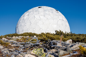 Abandoned dome of an old Soviet military radar from the Cold War. A huge structure in the form of a white sphere on the mountain. Tourist attraction of Magadan. Magadan region, Russian Far East.