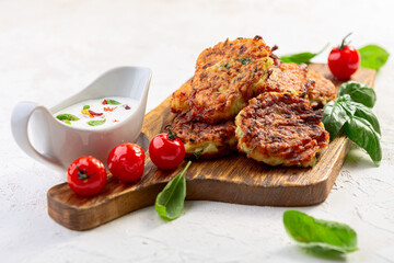 Zucchini fritters with yogurt sauce. Vegetarian cuisine.