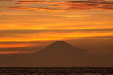 Fototapeta na wymiar 真っ赤な夕焼け雲を背にした洋上の富士山