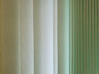 Fabric blinds in the form of green vertical stripes. 