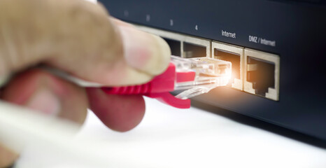 Man plugs internet cable into the router.LAN network and internet connection, Ethernet RJ45 cable plug to lan port,modem router. 