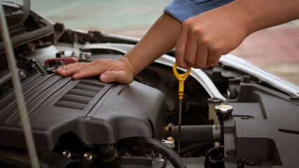 The young man's hand was measuring the level of his car oil.