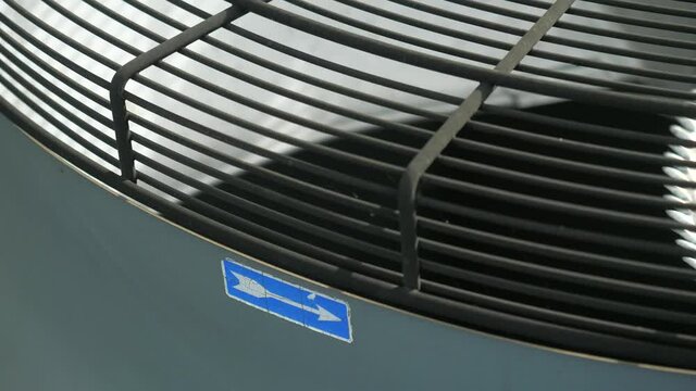 Industrial cooler propeller hidden under safety bar. Close up of an electric Industrial Fan.