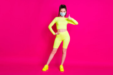 Full length photo of young woman dressed sportwear mask hand thumb up arm waist isolated pink color background