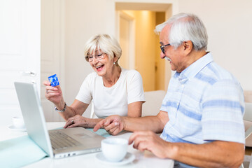 Fototapeta premium Excited senior woman looking at computer screen showing smiling middle aged husband online shopping sale on web site