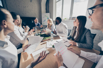 Portrait of nice attractive elegant stylish experienced skilled qualified coworkers discussing cost reduce finance project income growth at loft industrial style interior workplace workstation