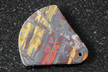 pendant from polished Jaspillite (Jaspilite) stone on black granite background