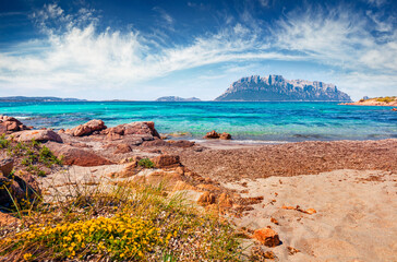 Sunny summer view of Tavolara island from Spiaggia del dottore beach. Bright morning scene of Sardinia island, Italy, Europe. Nice Mediterranean seascape. Beauty of nature concept background.