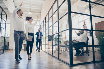 Full length photo of positive freelancers man woman go walk training hold hand greet colleagues sit table in boardroom workplace workstation