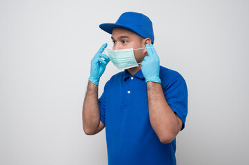 Blue delivery asian man wearing protection mask and medical rubber gloves on isolated white background safety deliver concept.