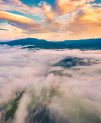 Fototapeta na wymiar View from flying drone. Dramatic morning scene of Carpathian mountains. Great sunrise on foggy mountain valley. Beauty of nature concept background..