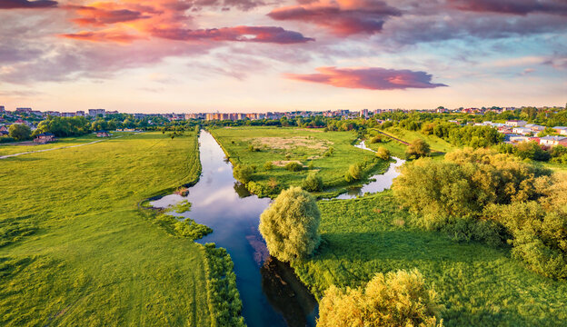 View from flying drone of outskirts of Ternopil city. Spectacular summer sunrise on Seret river. Beautiful morning cityscape of Ternopil, Ukraine. Traveling concept background.