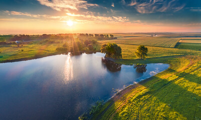 Fantastic summer sunrise on Stara Brykulia lake, Ternopil region. Wonderful rural scene from flying...