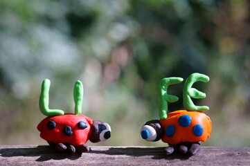 Two figures of ladybirds made of plasticine. Next to it is the inscription life.