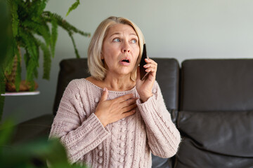 woman in a phone call sitting on a sofa in the living room in a house