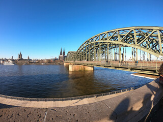 View of Cologne with the Great St. Martin Church, the Cologne Cathedral (Kolner Dom) and Hohenzollern Bridge from bank of the Rhine river, Germany.