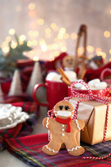 Gingerbread man cookies with protective face mask and Christmas gift boxes on Christmas decoration table.  Christmas and new year concept in new normal. マスクをしたジンジャーマンクッキーとクリスマスギフト