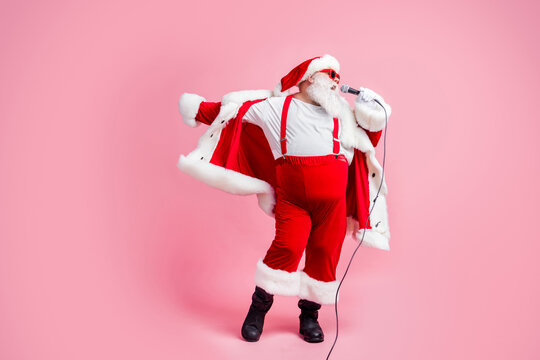 Full length photo crazy fat white grey hair beard santa claus big belly sing mic song enjoy x-mas christmas jolly party wear sunglass hat suspenders boots isolated pastel color background