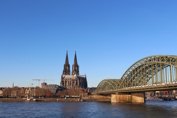 Fototapeta premium The Hohenzollern bridge over Rhine river on a sunny day. The Cologne Cathedral (Kolner Dom) in the city of Cologne, Germany. It is the largest Gothic church in northern Europe.