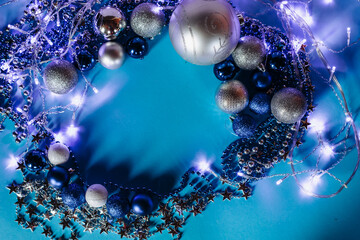Christmas decorations.Shiny Christmas balls of blue, white and silver colors of different sizes on a turquoise background.