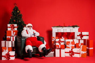 Portrait of his he attractive funky fat overweight cheerful Santa sitting in armchair playing video...