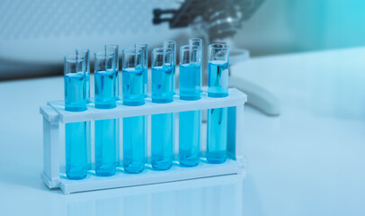 Close up row of glass test tube filled with blue liquid in laboratory. Chemistry or Biology class, education or science concept.