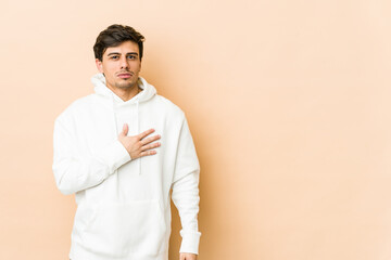 Young cool man taking an oath, putting hand on chest.