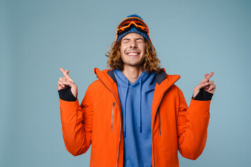 Young excited sportsman posing with fingers crossed for good luck