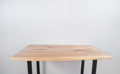 Wooden stylish table made of solid wood with epoxy resin on the background of the floor and wall....