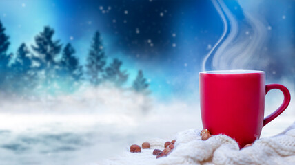 Red cup with coffee, tea on a snowy background, winter forest. A red cup against the background of a winter forest landscape on a soft, cozy scarf. Coffee, tea in the mountains.