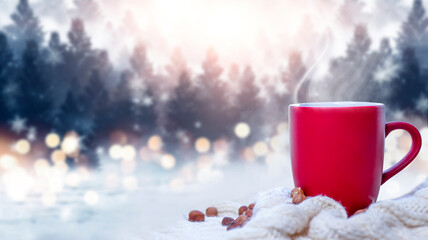 Red cup with coffee, tea on a snowy background, winter forest. A red cup against the background of...