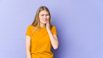 Young blonde woman isolated on purple background having a strong teeth pain, molar ache.