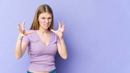 Fototapeta na wymiar Young blonde woman isolated on purple background upset screaming with tense hands.