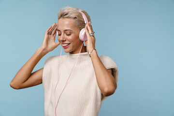 Happy beautiful girl listening music with headphones and smiling