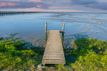 View of a jetty on the Wadden Sea at the North Sea in Butjadingen / Germany in the evening